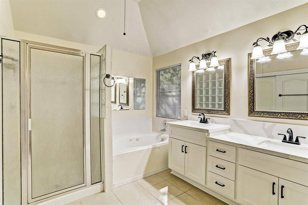 Primary bathroom with double vanities and quartz countertop
