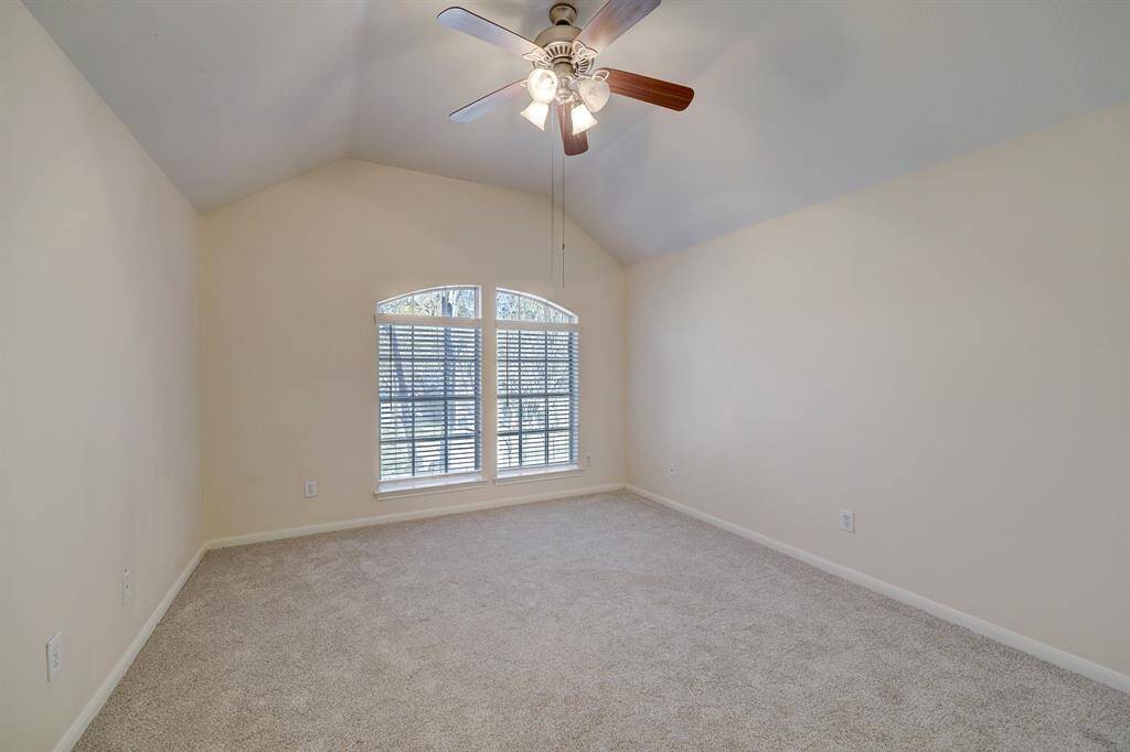 Second bedroom at front of home with fresh carpet and vaulted ceiling