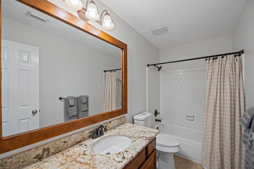 Upstairs features this full secondary bathroom with gorgeous granite countertops and shower/tub combination with tile surround!
