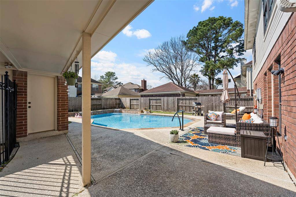 Step outside into your backyard oasis!  This breezeway leads to the garage, and the iron fence keeps all your stuff secure!
