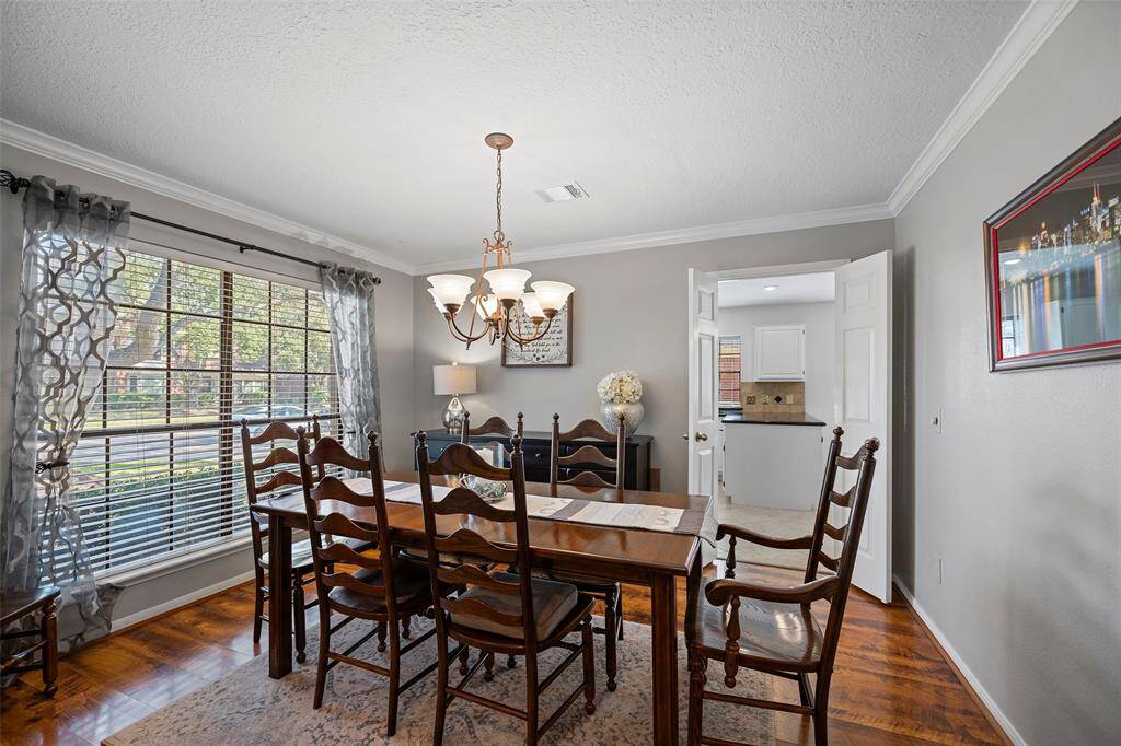 A classic style family room features crown molding, decorative chandelier and a large picture window, along with convenient access to the kitchen which is perfect for entertaining!
