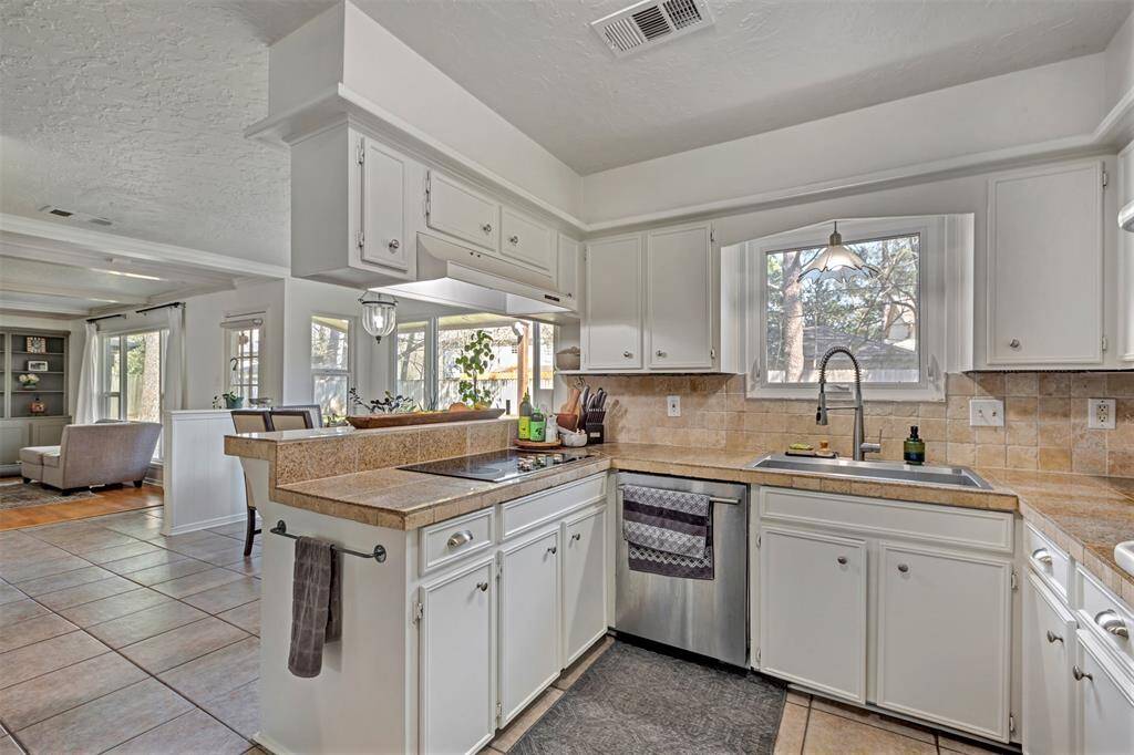 Recent cooktop & huge single bowl stainless sink, chef style faucet, all overlooking the backyard