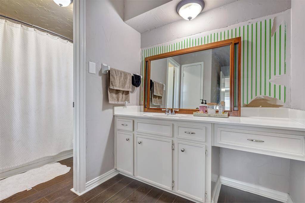 Primary shower has vintage wainscotting detail plus recent tile & plumbing fixtures