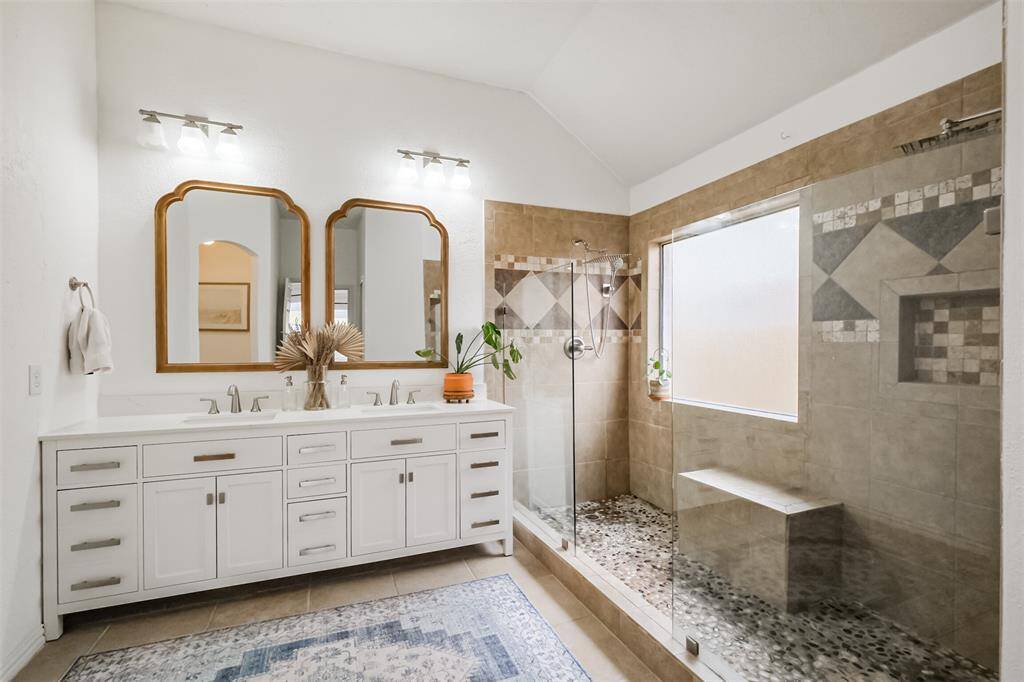 Updated cabinetry and mirrors along site a double shower for those busy mornings!