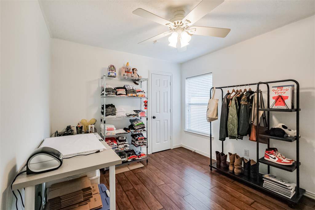 Bedroom number 2 with ceiling fan, large window and updated floors.