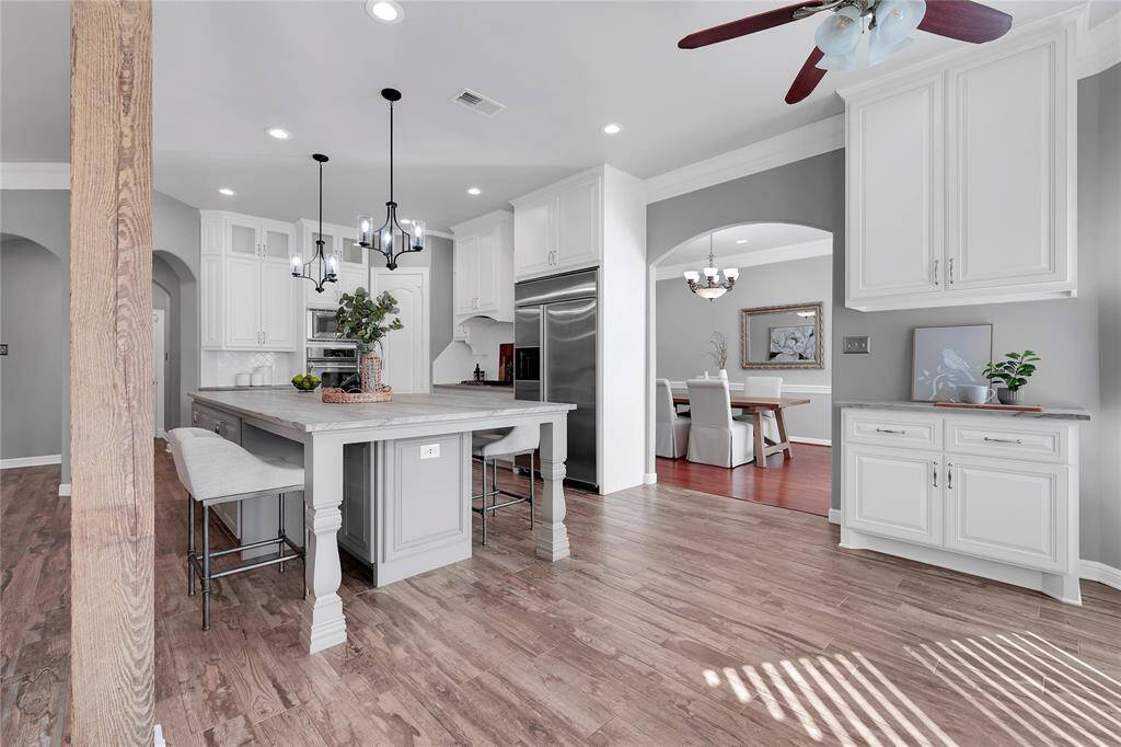 Additional kitchen features: 5 burner gas cooktop, built-in refrigerator, Jenn Air double ovens, farmhouse barn sink, trash compactor, walk-in pantry and subway tile backsplash.