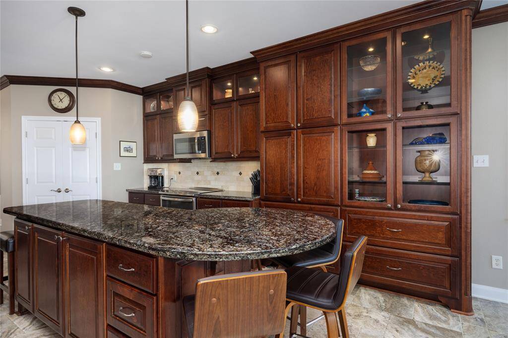 Custom kitchen cabinetry with lighting and crown molding by Benedettini of Rosenberg TX