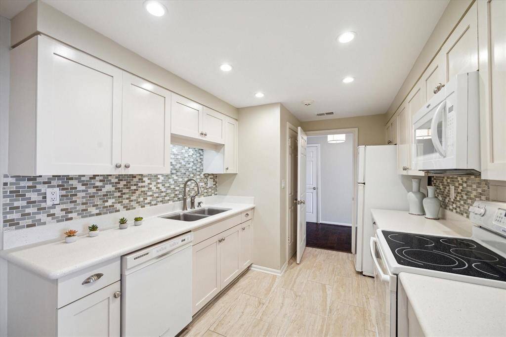 The cheerful Kitchen conveniently opens to the Foyer and to the Dining Room and Living Room.