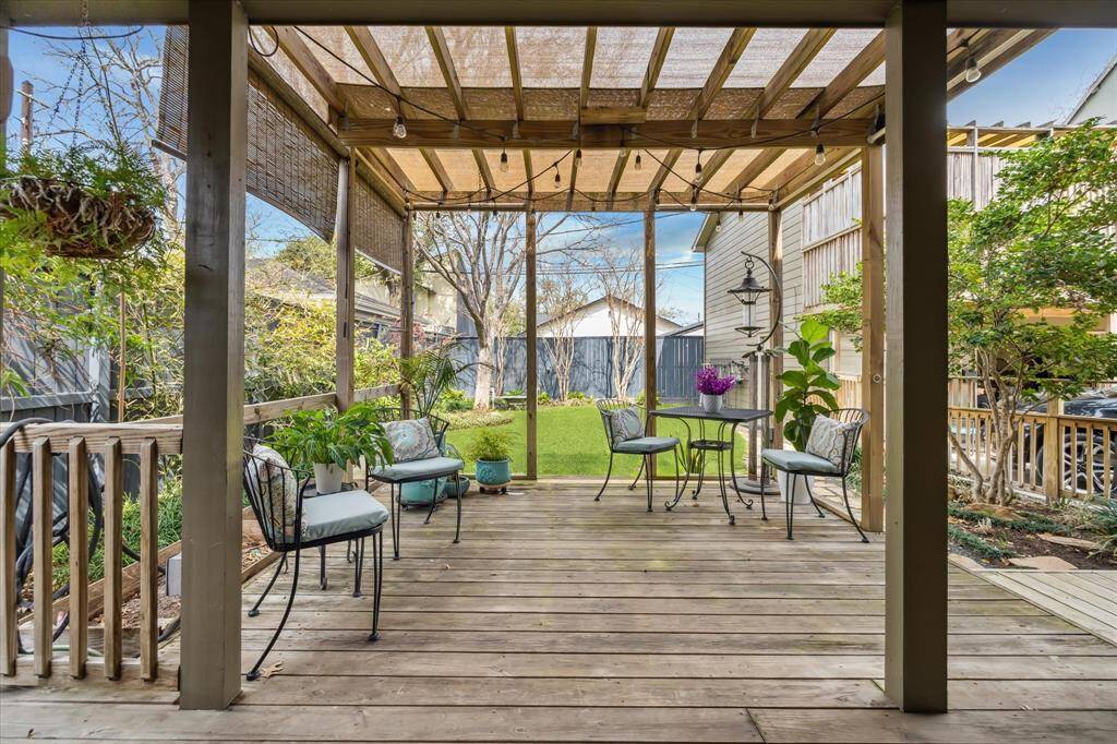 Main house covered patio overlooks green backyard.