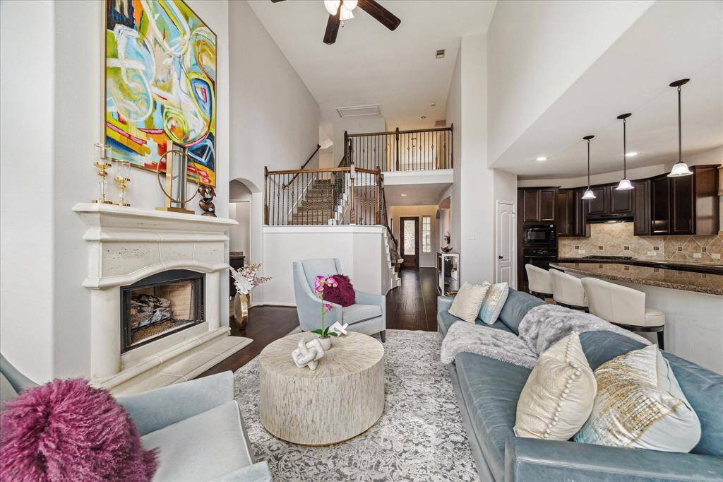 The spacious family room boasts  high ceilings, a cozy fireplace, wood flooring  and  it seamlessly connects to the kitchen and breakfast area. Open wrought iron staircase leads to upstairs Game Room, 3 bedrooms, 2 baths, plus loft area.