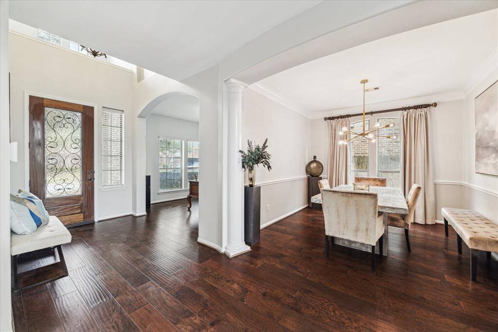 Elegant foyer boasts high ceiling & art display areas with home office to the left and dining area.