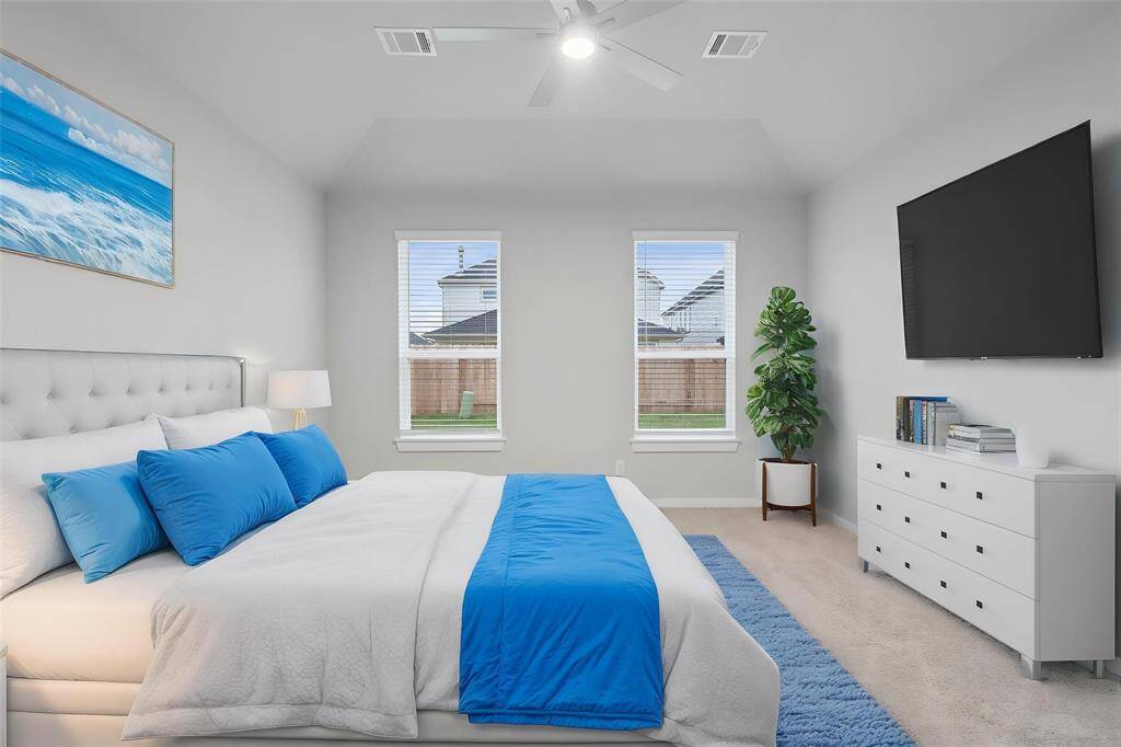 Come and unwind after a long day in this magnificent primary suite! This spacious room features plush carpet, warm paint, high ceilings, ceiling fan, and large windows with privacy blinds!