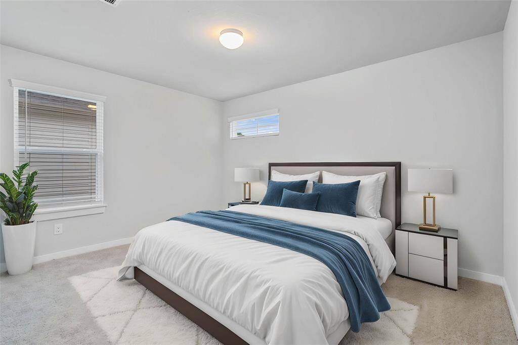 Secondary bedroom features plush carpet, custom paint, high ceilings, lighting, closet space, and a large window with privacy blinds.