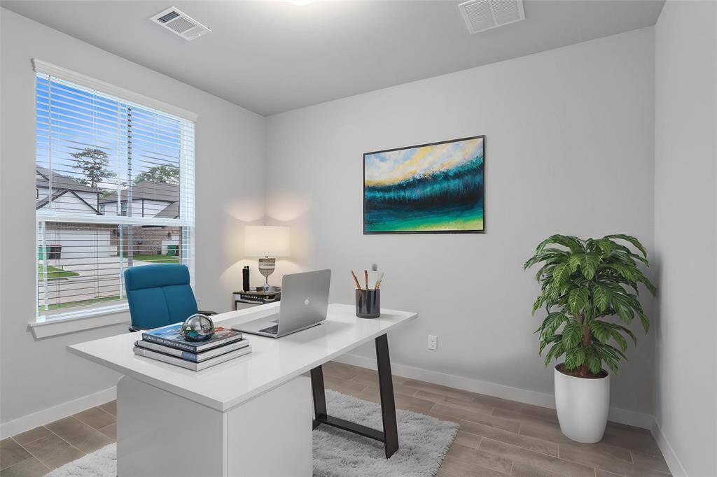 Quietly nestled in front of the home is the handsome home office. Featuring wood look tile flooring, high ceilings, lighting, large window with privacy blinds, and custom paint.