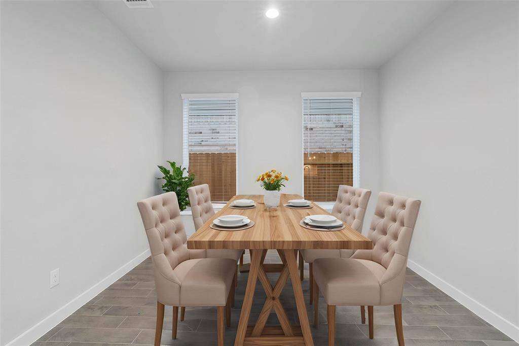 You and your guests will certainly dine in style in this amazing formal dining room! Featuring large windows with blinds, neutral paint, high ceilings, recessed lighting, and tile flooring! Perfect space to entertain family and friends!