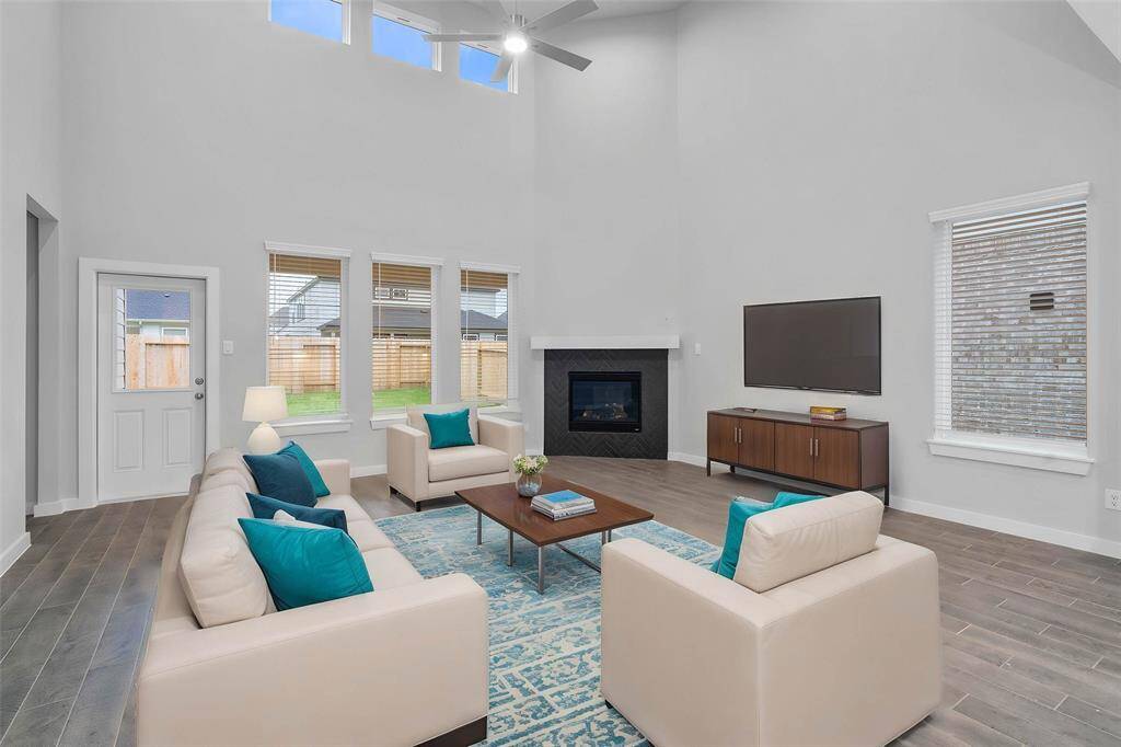 Gather the family and guests together in your lovely family room! Featuring fireplace with wood mantel, high ceilings, recessed lighting, ceiling fan, custom paint, gorgeous wood look tile floors, and large windows that provide plenty of natural lighting throughout the day.