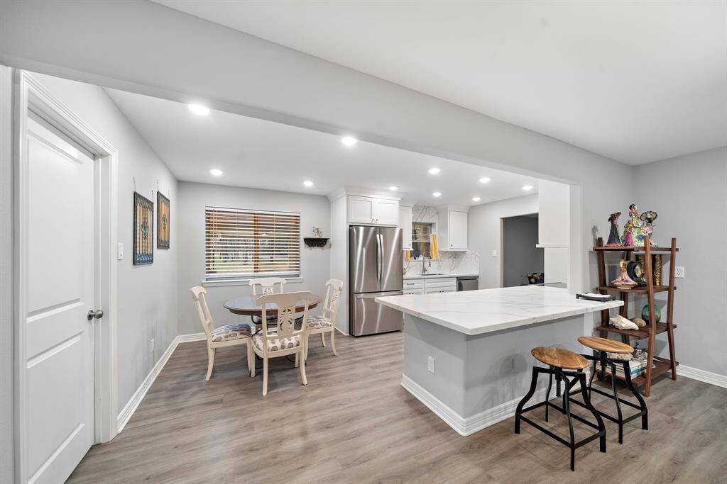 Designed for both style and function, the open kitchen layout flows seamlessly into the main living area, making it ideal for entertaining. The oversized counter-height bar provides additional seating and prep space, perfect for casual dining or gathering with guests.