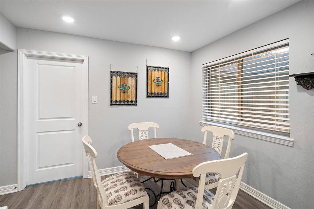 The breakfast nook is bathed in natural light from a large window, creating a bright and inviting space for morning coffee or casual meals. The neutral tones and updated recessed lighting add to the room’s modern appeal.