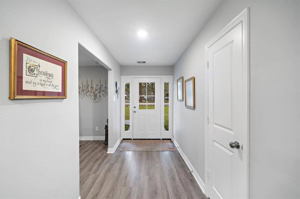 A bright and inviting entry sets the tone with a modern front door, sidelights for natural light, and sleek flooring that flows throughout the home.