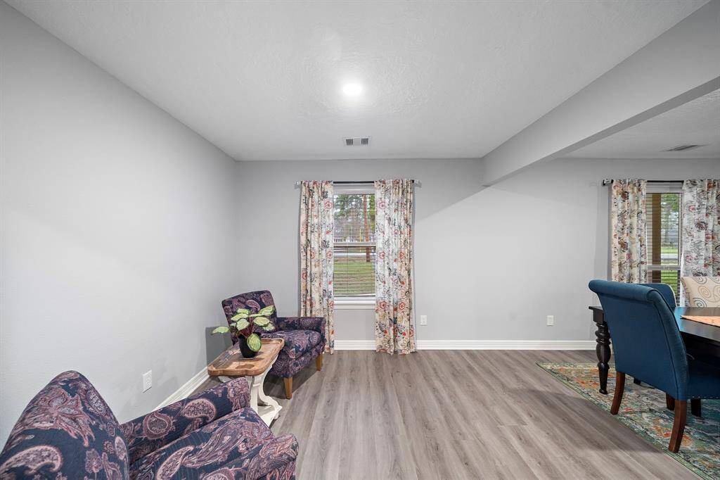 The formal living area connects effortlessly to the dining room, offering a spacious layout with large windows for natural light.