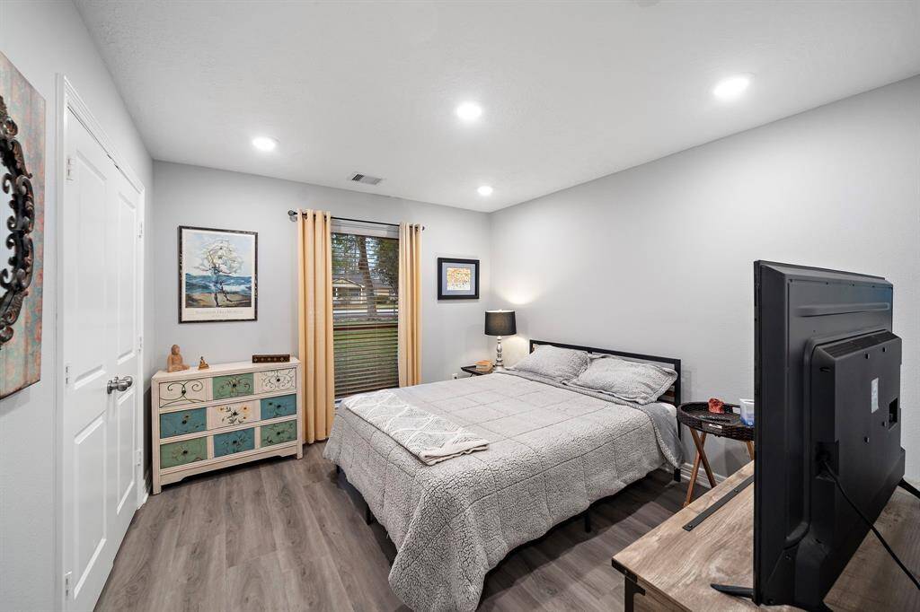 A spacious secondary bedroom with recessed lighting and a large window for natural light.
