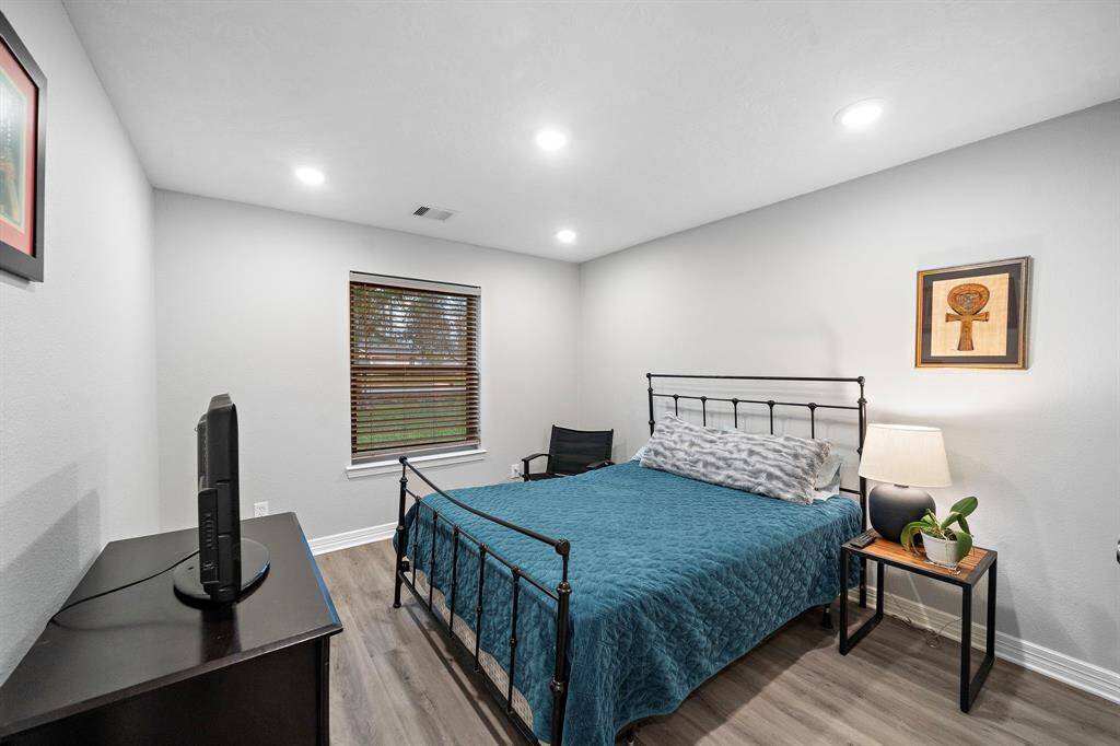 Another well-sized bedroom with recessed lighting and a window, creating a comfortable and functional space.