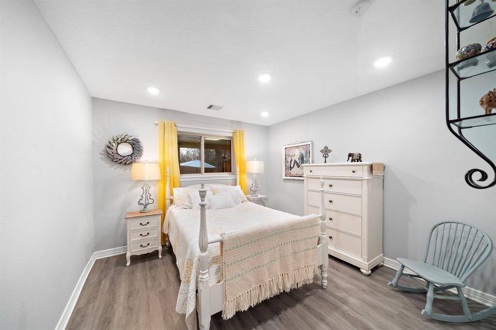 Bright and inviting, this bedroom features soft neutral tones and a large window overlooking the backyard.
