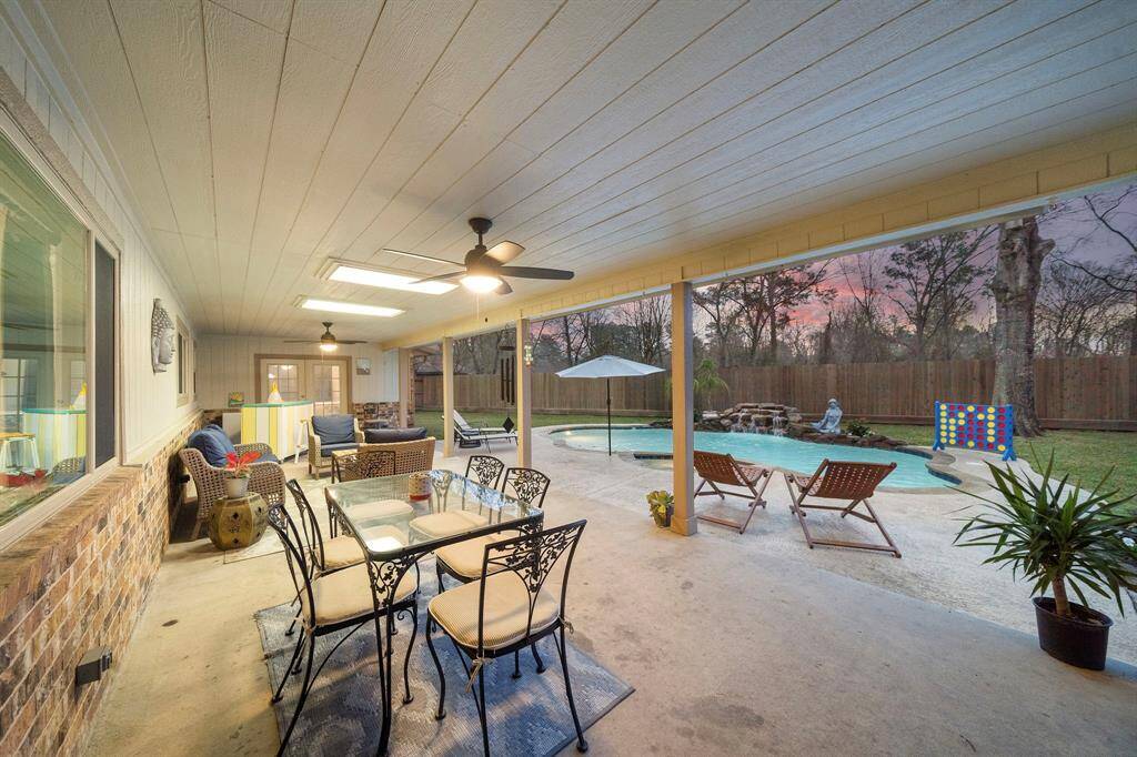 Step into your private retreat, where a sprawling backyard oasis awaits. The covered patio extends across the back of the home, offering a shaded area ideal for relaxation or entertaining. Outfitted with ceiling fans, ample seating, and a charming bar, this outdoor space is designed for comfort and convenience.