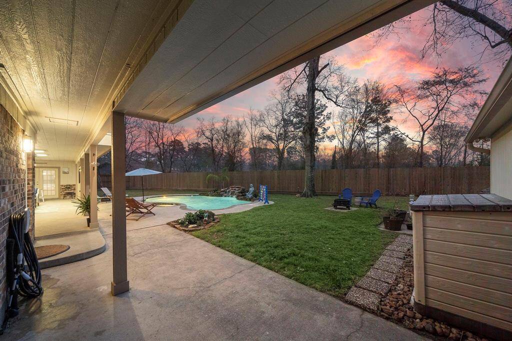 The covered patio opens directly to the sparkling pool, providing a perfect blend of shade and sunshine. Enjoy dining al fresco while overlooking the lush backyard retreat.