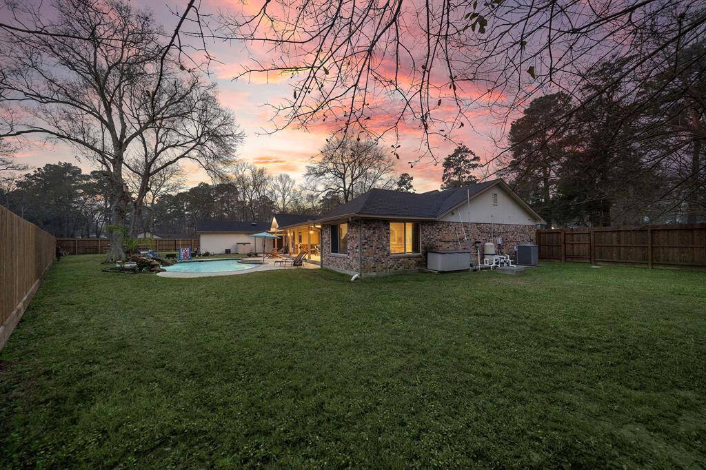 The expansive lawn provides plenty of space for recreation, pets, or gardening, all enclosed by a privacy fence for added seclusion.