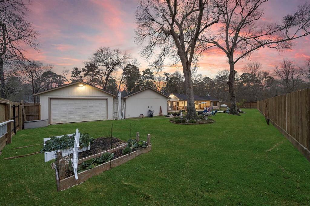 The expansive fenced yard offers plenty of space for pets, gardening, or outdoor games, while mature trees provide a scenic natural setting.