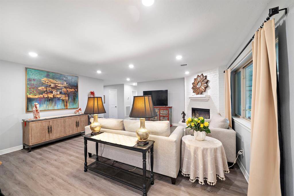 Cozy fireplace, featuring a white brick surround and sleek mantle, adding warmth and charm. Positioned at the heart of the home, this space is ideal for gathering with family and friends.