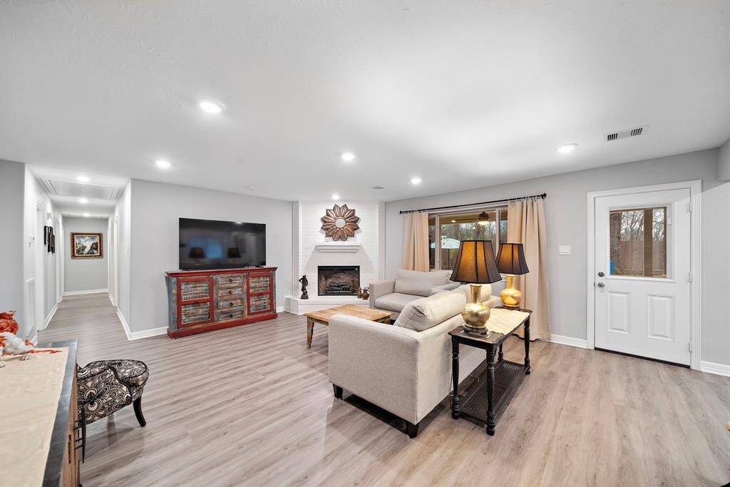 The large picture window frames a beautiful backyard view, allowing natural light to flow throughout the room. A thoughtfully placed glass door provides convenient access to outdoor living spaces, enhancing the home’s indoor-outdoor appeal.