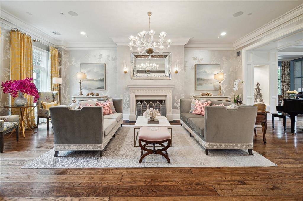 Back at the grand entry, you will be dazzled by the spacious living room with its Gracie custom, hand painted wallpaper and the handsome limestone fireplace mantle. The living room flows directly into a beautiful piano room with its art niches and looks directly to the pool, porches and grounds.