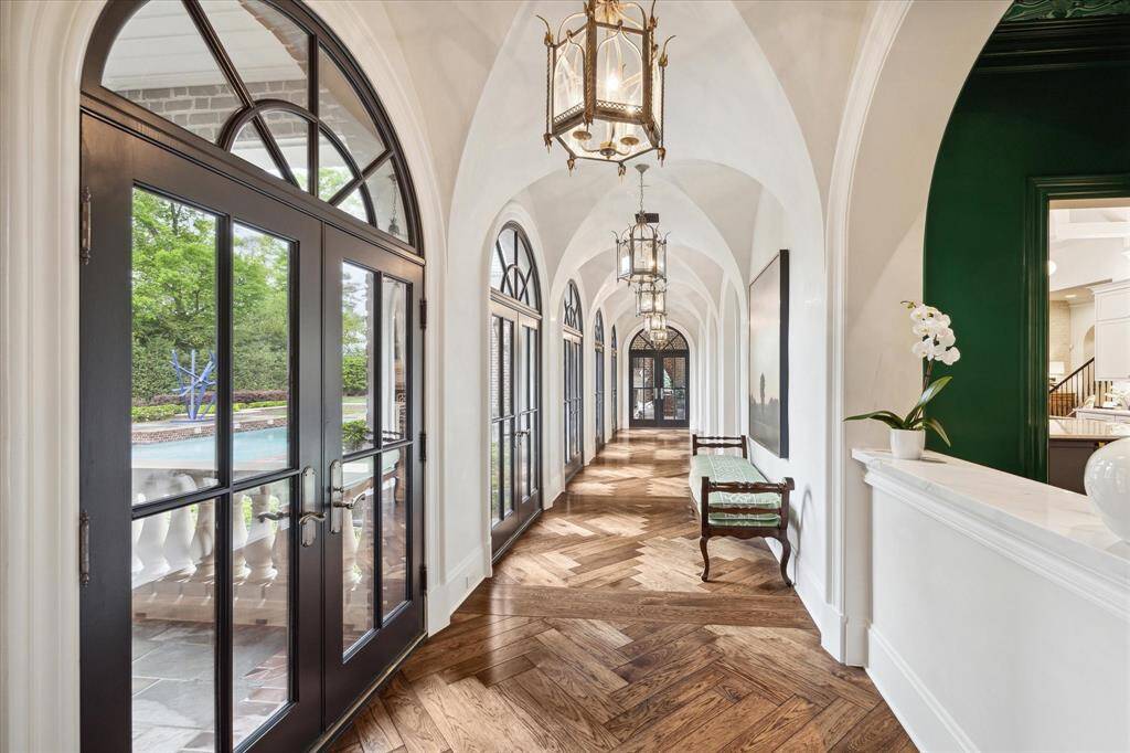 The light filled gallery hallway with its plastered groin-vaulted ceiling and walls lead you to the kitchen, breakfast room and sunroom which comprise the true heart of the home. Notice the sets of French doors that line the entire hallway allowing immediate access to the porches and pool. At the end of the hallway, you will find a  loggia which extends the living space to the outdoors.