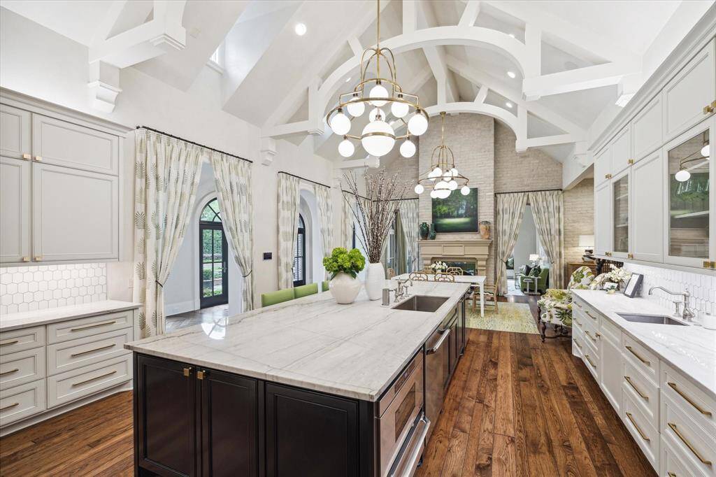 You have now reached the heart of the home - the kitchen, the breakfast room and sunroom behind the curtains. The oversized kitchen is grounded with a massive island with quartzite countertop, lots of additional storage, a second sink and plenty of seating for casual eating or while family and friends hangout. Be sure to look up at the ceiling!