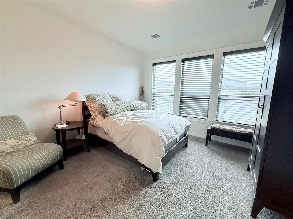 Serene Primary Suite – The spacious primary bedroom offers a tranquil retreat with plush carpeting, large windows, and a spa-like ensuite bath.