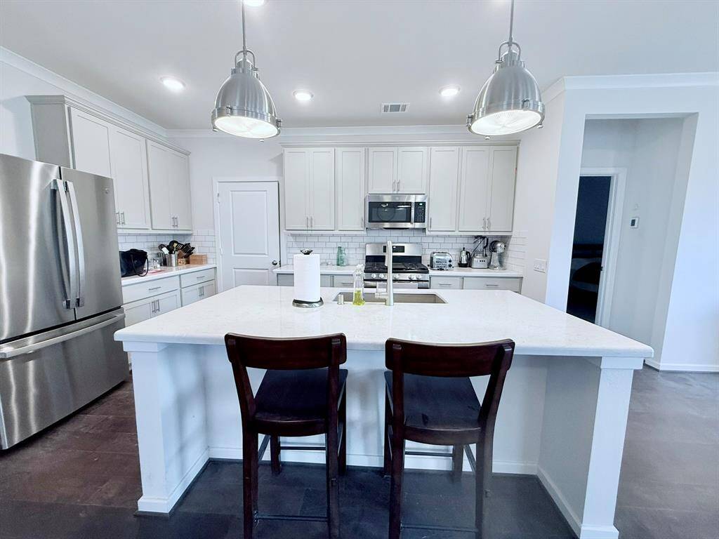 . The open kitchen boasts modern appliancesand an island, perfect for entertaining.