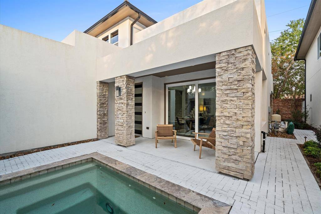 The courtyard includes a small pool or spa complemented by minimalist landscaping with low-maintenance shrubs and greenery