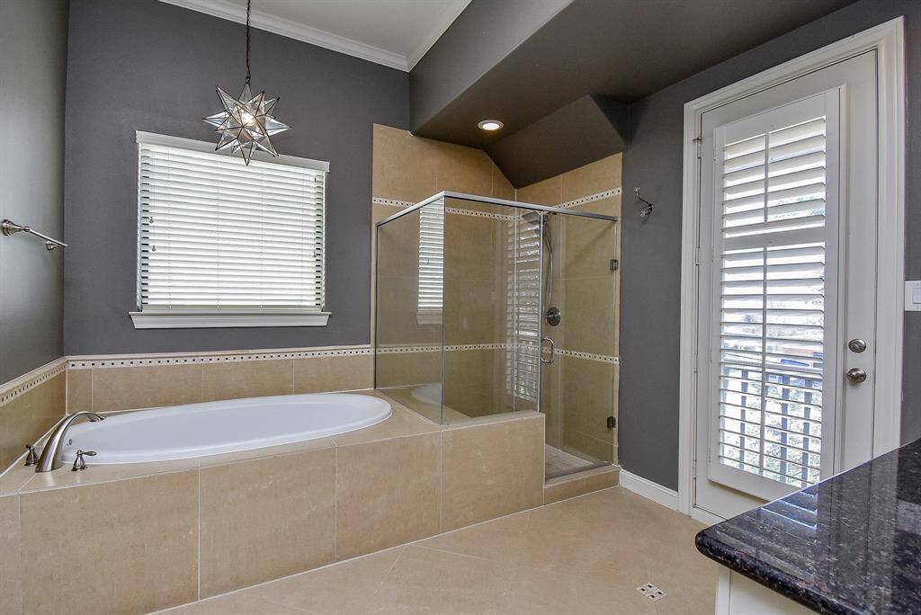 The primary bath features double vanity sinks, large soaking tub, and glass enclosed shower.