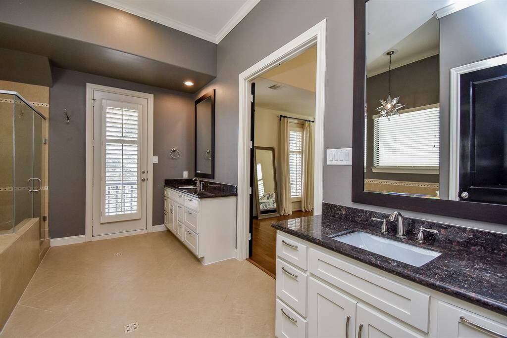 The primary bath features double vanity sinks, large soaking tub, and glass enclosed shower.