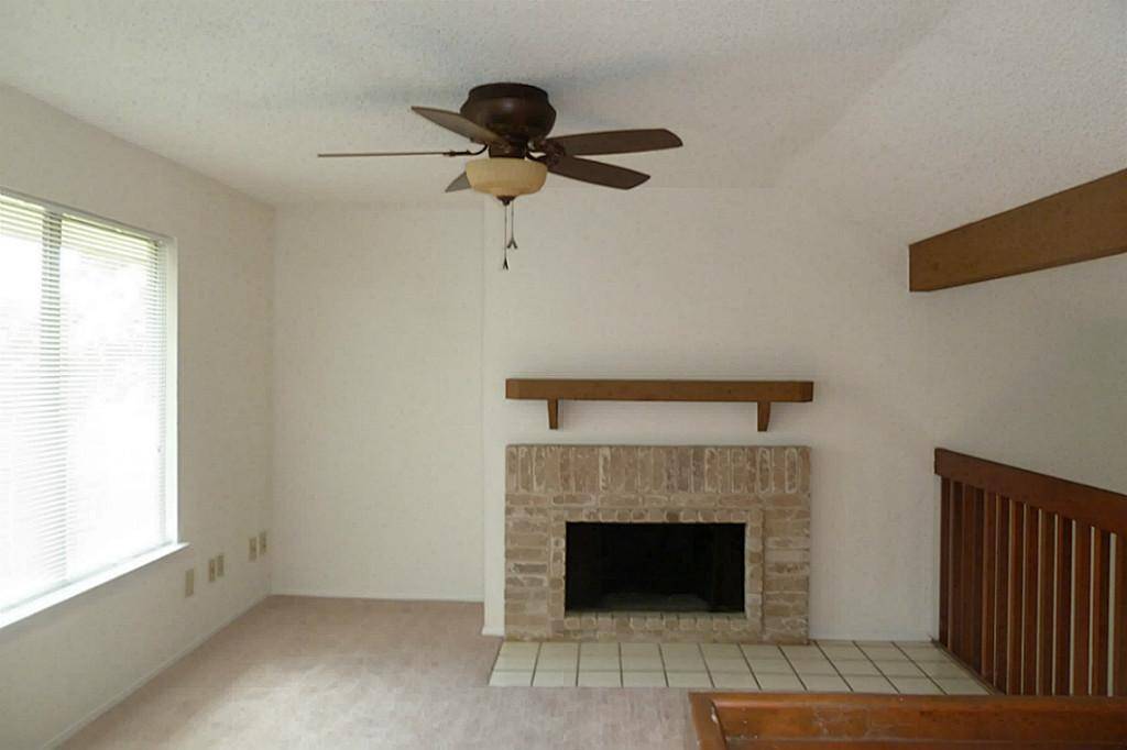 Second floor loft offers a wood burning fireplace, vinyl wood flooring, (carpet has been replaced)  updated fan and great view of the green space