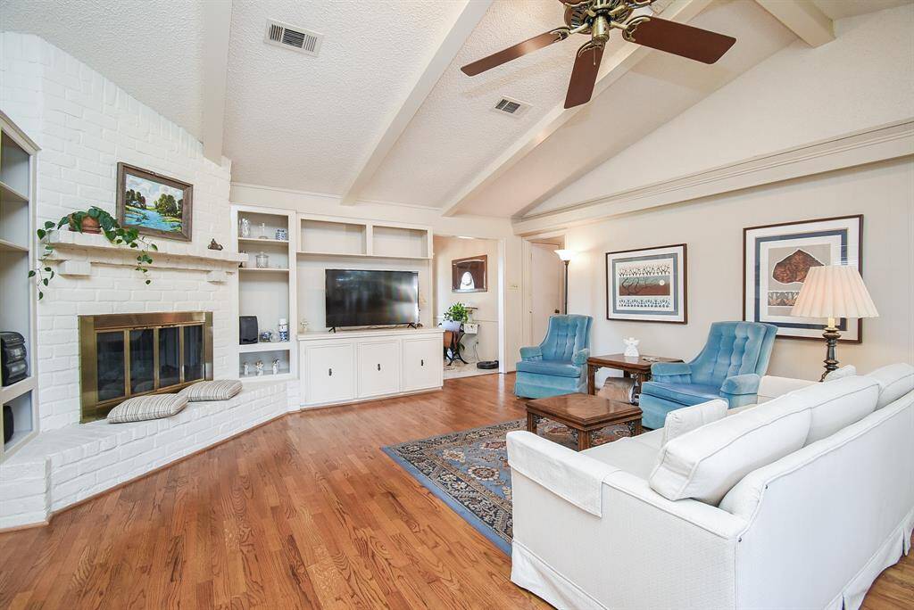Great view of fireplace and extended hearth Gorgeous wood floors and ceiling beams add a touch of class