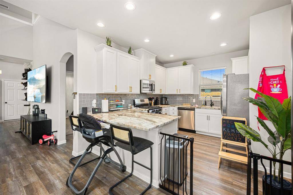 Kitchen with shaker cabinets and stylish gold drawer and door pulls.