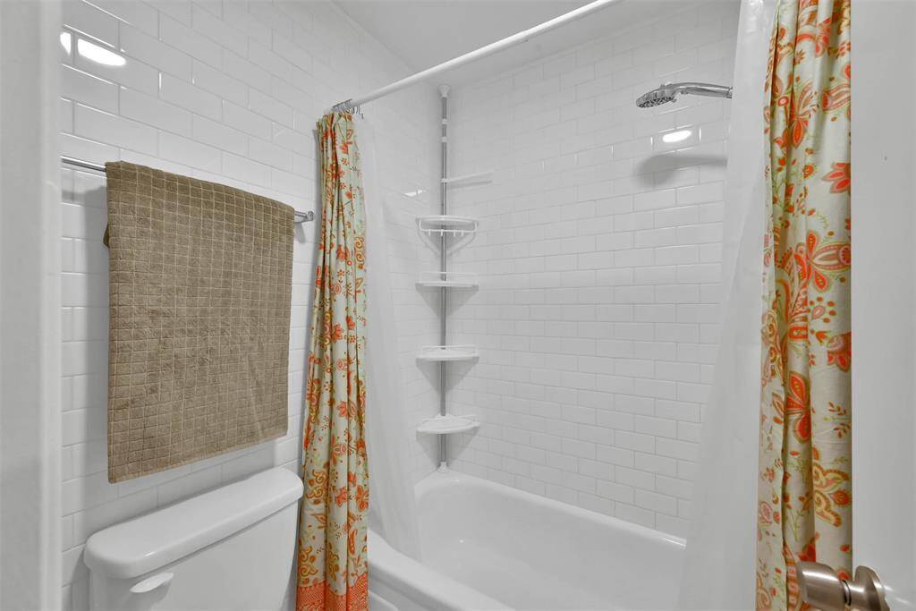 Beautiful tilework surrounding tub and toilet.