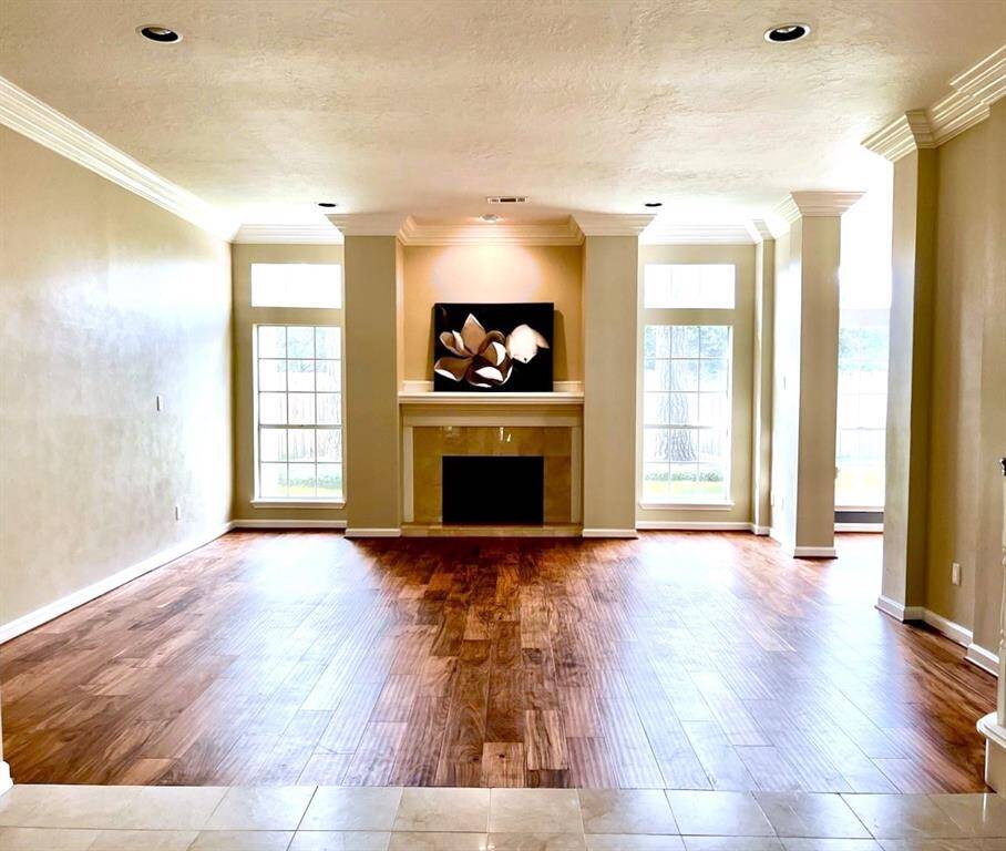 This charming family room features beautiful engineered wood flooring and crown molding.