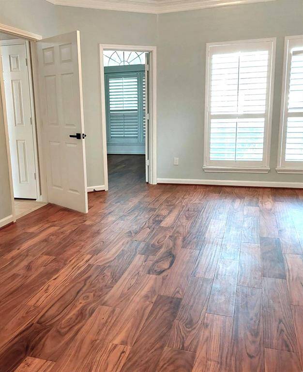 Primary  bedroom with crown molding, ceiling fan,  flooring, mirrored barn door , paint, everything is new!