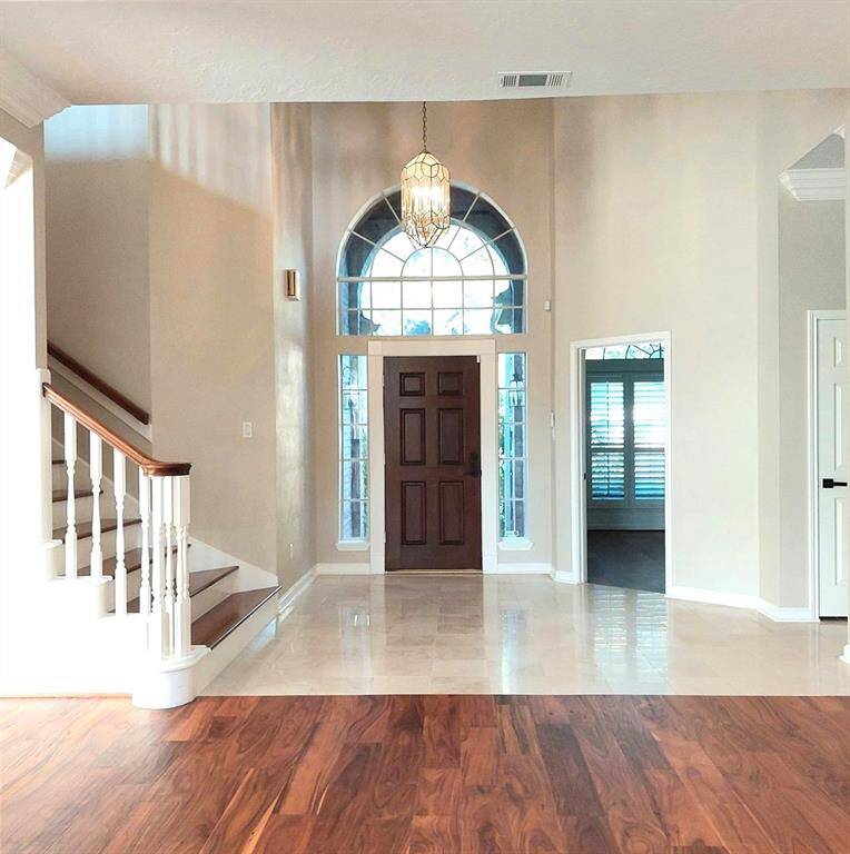 This picture was taken from the family room area of the foyer. You can see the front entry and door leading to office. The new wood staircase is also featured.