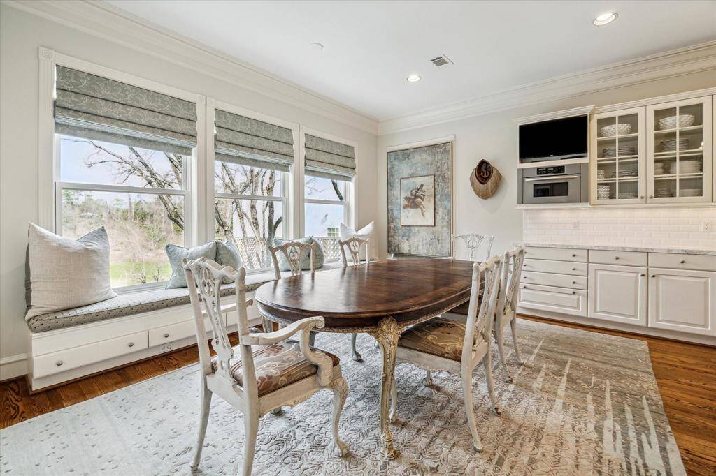 Open to both the kitchen and family room, this breakfast nook is perfect for everyday meals and relaxed gatherings. Custom crown molding and designer neutral wall paint add an elegant touch to the room's welcoming atmosphere.
