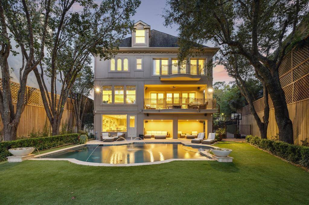 The backyard of this luxury estate is an oasis featuring a heated pool and spa with elegant fountain features, surrounded by lush landscaping and a pristine, year-round artificial turfed lawn. Two balconies and a covered patio provide ideal spaces for outdoor entertaining, all with stunning views of the pool. A private, gated driveway leads to the attached three-car garage, with additional parking available for up to three more vehicles.